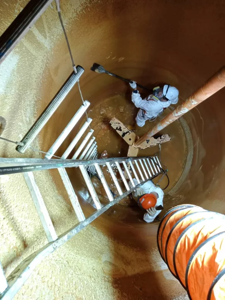 two men performing industrial tank cleaning services