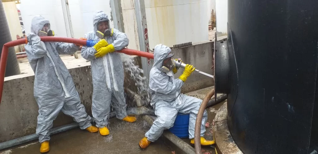 three men cleaning a chemical tank as a service